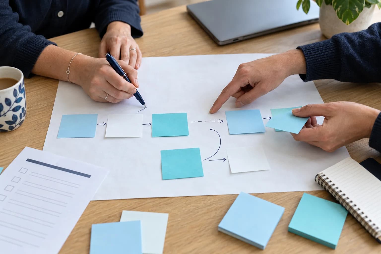 Illustrative scene of colleagues mapping a handover with paper notes and identifying a gap between steps.